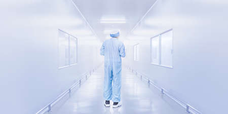 modern interior of laboratory or factory with backside of science worker in coverall uniform, science development concept backgroundの写真素材