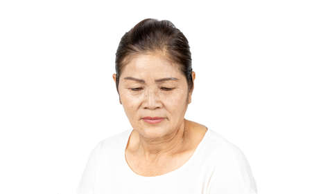 elderly asian woman portrait 60-70 years old no make up with white clothes black hair and hazel eyes isolated on white backgroundの写真素材