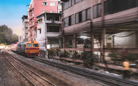 Fast vintage asian train diesel locomotives head to the city in motion shotの写真素材