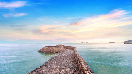 The rock pier with beautiful calmness sunrise seascape at koh chang in Thailandの写真素材