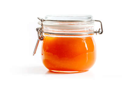 homemade jam orange flavor in transparent glass jar isolated on white background