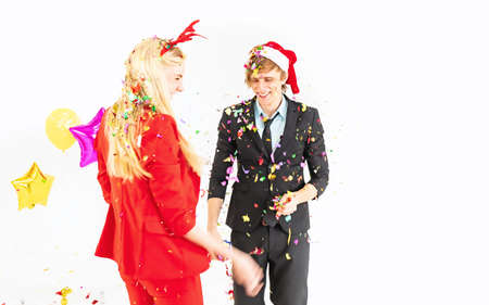 Teenage hansome man and pretty woman enjoy with colorful confetti in celebration hangout partyの写真素材