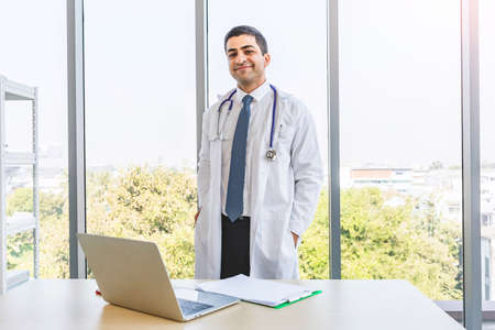 Asian doctor in gown uniform working with happiness smiling at hospital or medical clinic, Healthty and Occupation conceptの写真素材