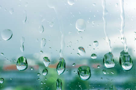 Rain drops on window glasses in rainy day with selective focusing, rainy season weather