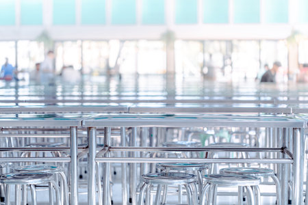 Modern interior of cafeteria or canteen with stainless steel chairs and tables, eating room in selective focusの写真素材
