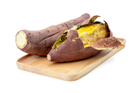Roasted sweet potato healthy nutrition food on a wooden plate isolated on white backgroundの写真素材