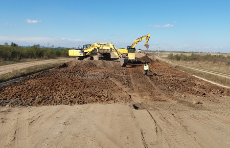 Excavators and truck on construction siteの写真素材