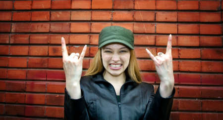 Cute rocker girl with old brick wall as backgroundの写真素材