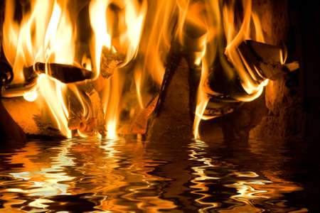 Flames from burning wood reflecting in water