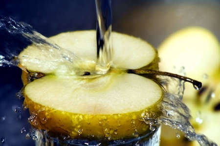 Close up on water splashing over sliced appleの写真素材