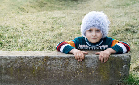 Smiling playful kid with winter white hat on his headの写真素材