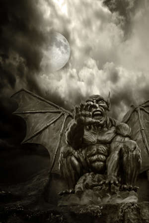 Night demon - close-up on frightening statue, with moon emerging from cloudsの写真素材
