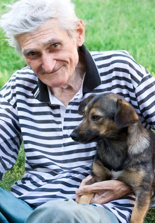 Portrait of happy male senior with his best pal, a cute dogの写真素材