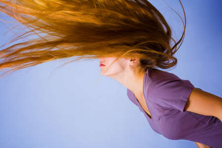 Active blond woman with her long hair in motionの写真素材