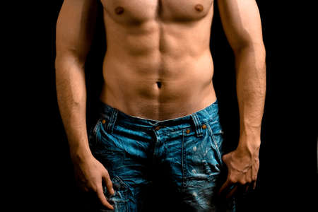 Torso of muscular man with nice abdomen over black