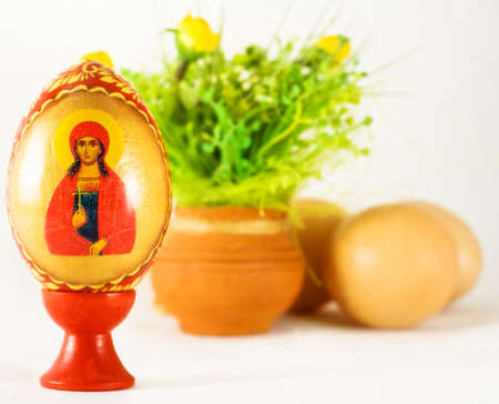 Easter and religion - painted egg and ornaments over whiteの写真素材