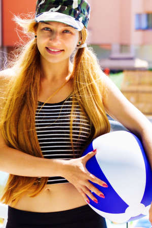 Summer leisure - portrait of active happy woman holding a ballの写真素材