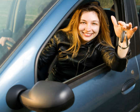 Portrait of happy woman with keys from her new car