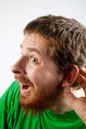 Listening concept - funny curious man with hand at earの写真素材