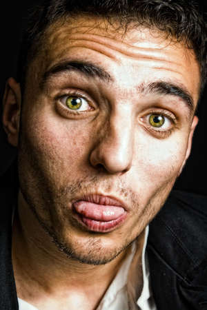 Guy with tongue out making a silly faceの写真素材