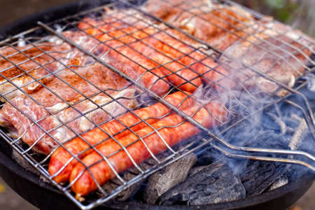 Barbecue with sausages and pork steakの写真素材