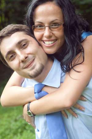 Outdoor portrait of playful cute young couple huggingの写真素材