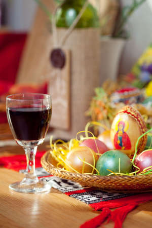 Easter colorful eggs and wine glass on table