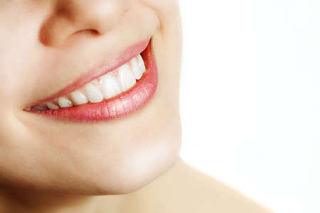 Fresh smile of woman with healthy teeth over whiteの写真素材