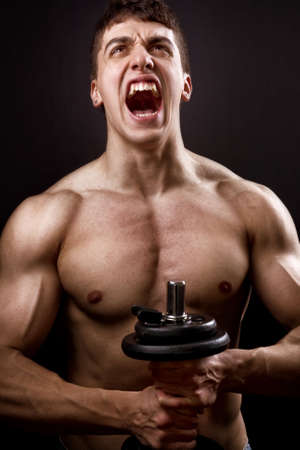 Loud scream of powerful muscular bodybuilder over blackの写真素材