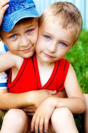Hug of two cute loving brothers outdoorsの写真素材