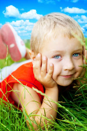 Portrait of happy cute child in the grassの写真素材