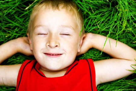 Happy dreaming child on fresh green grassの写真素材