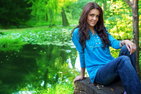 Beautiful brunette woman outdoor near forest lakeの写真素材