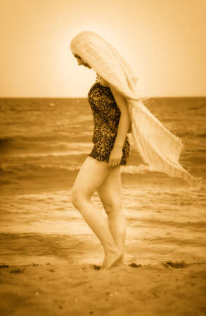 Barefoot woman with veil on peaceful sunny beachの写真素材