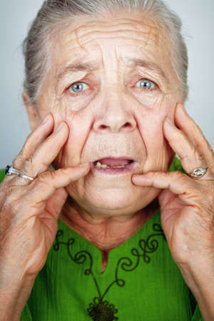 Portrait of scared and worried senior wrinkled lady