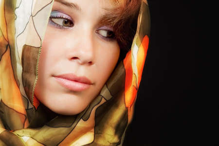 Elegant sensual young woman with colorful vail over black