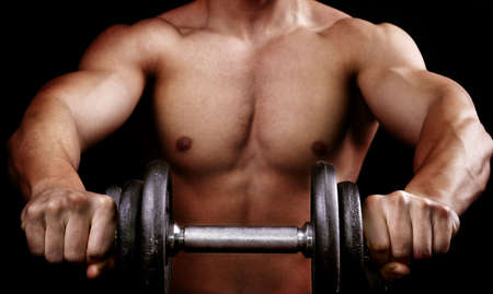 Powerful muscular man holding metal workout weightの写真素材