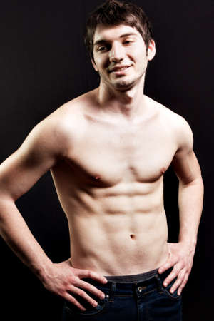 Shirtless sexy man with muscular abdomen over blackの写真素材
