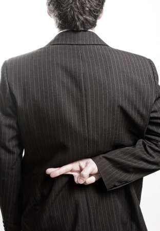 Liar business man with crossed fingers at backの写真素材