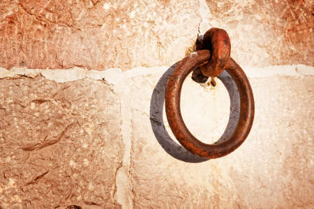 Backdrop of stone wall and rusty metallic ringの写真素材