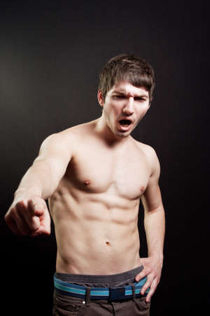 Scream of muscular sexy man over black backgroundの写真素材