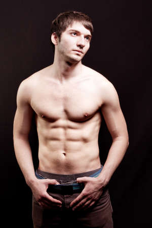 Shirtless young guy with sexy abs over blackの写真素材
