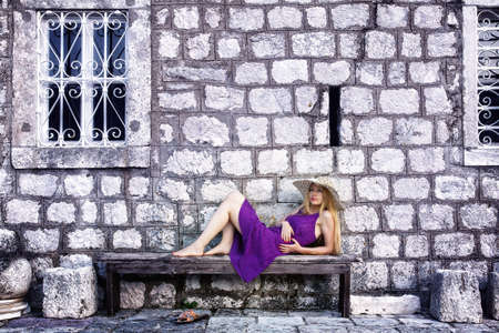 Fashion shot of elegant cute woman near stone wallの写真素材