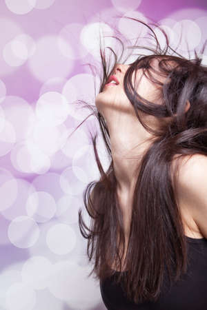 Dancing young brunette woman with hair in motionの写真素材