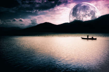 Fantasy landscape - moon, lake and fishing boatの写真素材