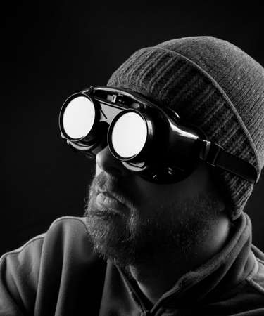 Man wearing protective goggles over black backgroundの写真素材