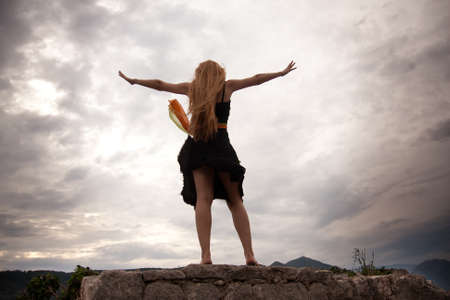 Freedom concept - adventurous woman on mountain peak