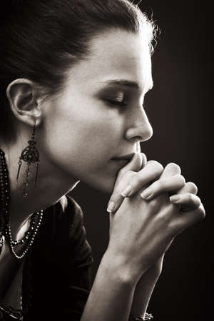 Faith and religion - spiritual woman praying in darknessの写真素材