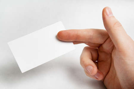 Hand holding blank business card over whiteの写真素材