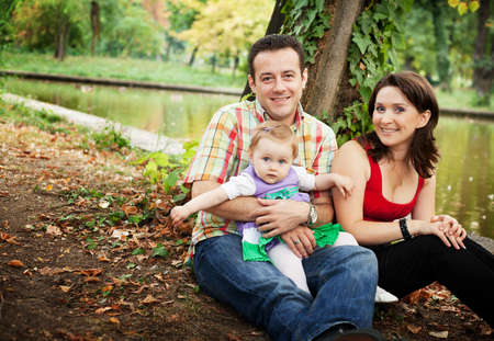 Family portrait - mother father and baby daughter outdoorの写真素材